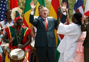 U.S. President George W. Bush dances with Senegalese dance troup during Malaria Awareness Day event in Rose Garden